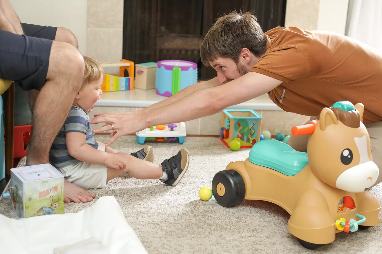 Two toddlers playing together with toy food, practicing social communication