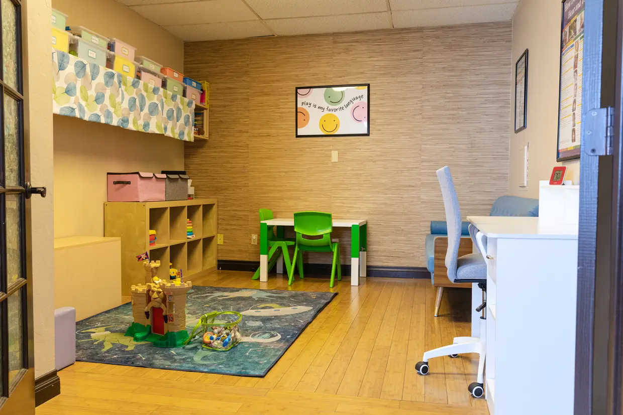 Genevieve laughing while holding a dental model during a therapy demonstration